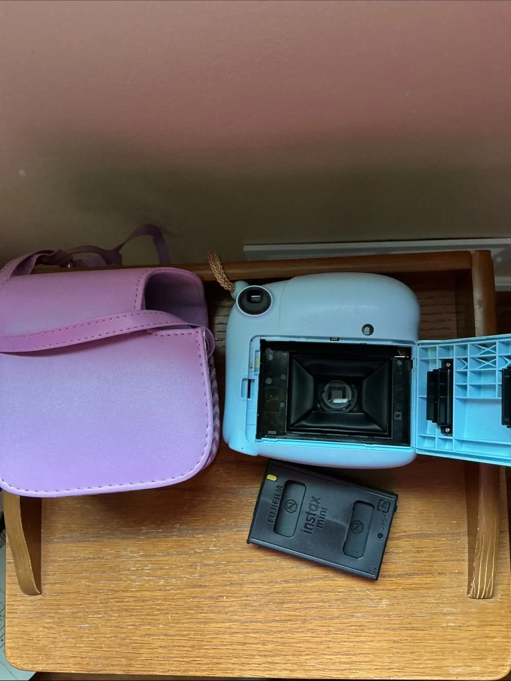 Instax Mini instant camera in light blue with pink carrying case